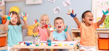 Cute children with painted palms at table indoor